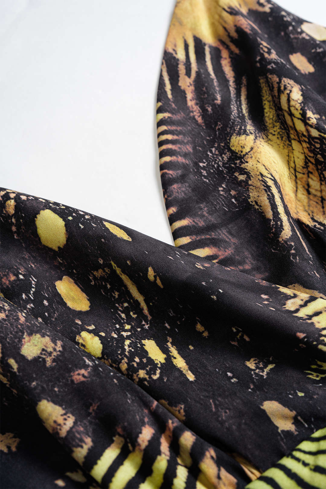 Ärmelloses, asymmetrisches Minikleid mit tropischem Muster und Metallkette