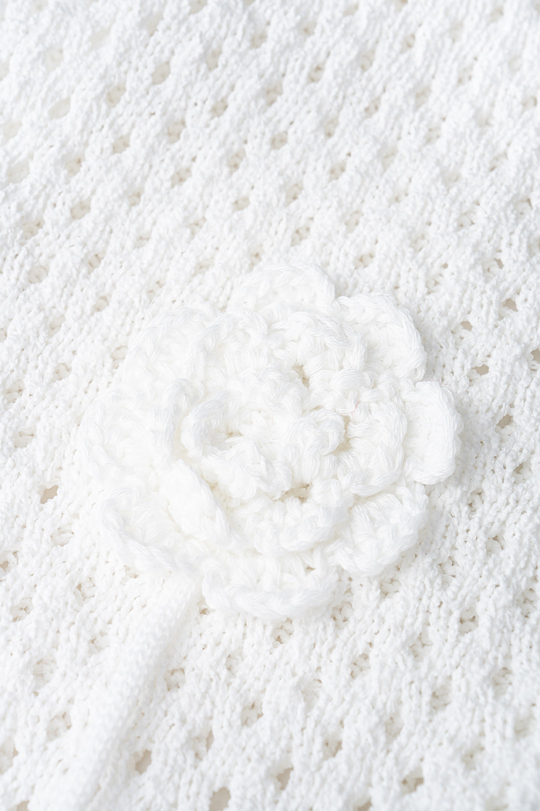Mini-robe sans manches en maille ajourée avec décolleté en V et motif floral.