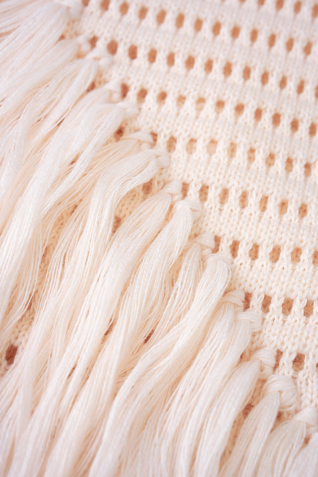Mini-robe sans manches en maille ajourée à col rond et ourlet à franges